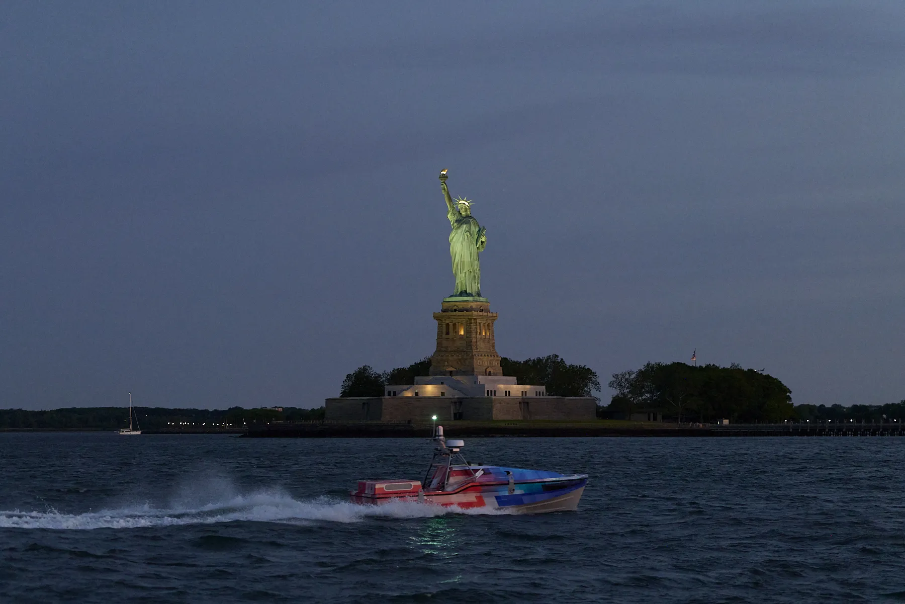 Saronic Corsair vessel racing past the Statue of Liberty